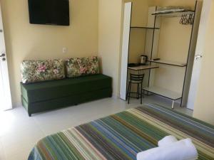 瓜鲁雅Pousada Porto Paraiso, o seu Paraíso Escondido no Guarujá的客厅配有绿色沙发和桌子