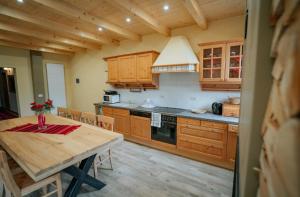 莫伊塞Casa DAVIDEN的厨房配有木柜、木桌和用餐室