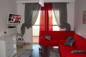 艾西拉Appartement de luxe的客厅设有红色的沙发和窗户。