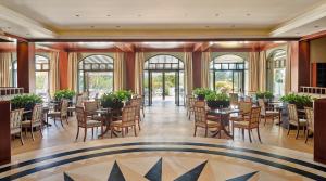 塞萨洛尼基塞萨洛尼基凯悦酒店的用餐室设有桌椅和窗户。