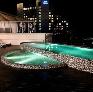 旌善Pine Forest Jeongseon Alpine Resort的一座游泳池,在晚上在一座建筑的顶部