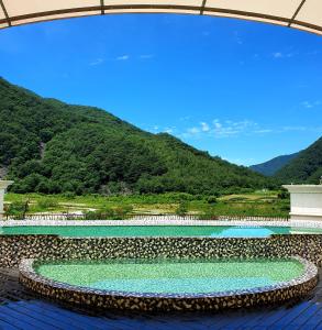 旌善Pine Forest Jeongseon Alpine Resort的山水池的背景