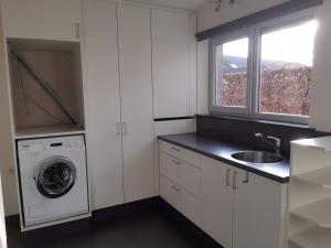 NeerpeltHoevetoerisme Op 't Zand的白色的厨房配有水槽和洗衣机