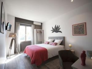 波尔多La Chartreuse - Bordeaux的一间卧室配有一张带红色毯子的床