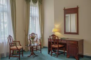 卡罗维发利米尼翁酒店的客房设有桌子、椅子和镜子
