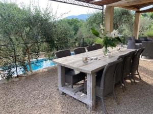 勒鲁雷Mas de charme au milieu des oliviers的一张带椅子的木桌和一张桌子