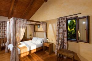 圣特里亚斯Cretan Exclusive Villas的一间卧室设有一张床和一个窗口