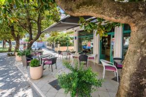 梅特科维奇MB酒店的室外咖啡厅设有桌椅和树木