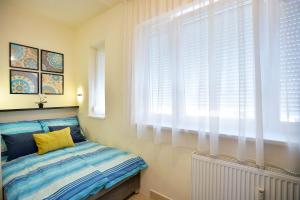 埃格尔NETTA APARTMAN的一间卧室配有一张床和一扇带白色百叶窗的窗户