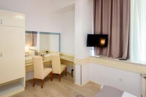 梅特科维奇MB酒店的客房设有带椅子的书桌和电视。