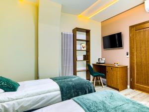 琴斯托霍瓦GRONO Apartamenty的酒店客房设有两张床、一张桌子和一台电视。