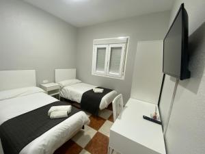 Alhama de AlmeríaFONDA CHIQUITO的小房间设有两张床和一台平面电视