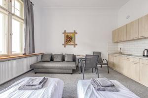 奥尔什丁Stara Piekarnia - Pułaskiego 3的客房设有两张床、一张桌子和一张沙发。