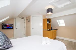 伦敦德里Quay 8的卧室配有白色的床和电视