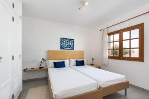 蒂亚斯Villa Sol 9的一间卧室配有一张带白色床单的床和一扇窗户。