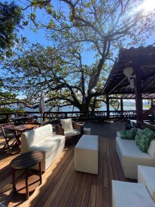 尼泰罗伊Pousada Camarote Itaipu的一个带沙发和桌子的甲板和一棵树