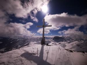 萨尔巴赫Appartement Berghof的雪覆盖的山顶上的十字架