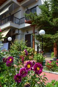 帕拉塔蒙Manos Kritikakis Apartments的鲜花盛开的房子前的花园