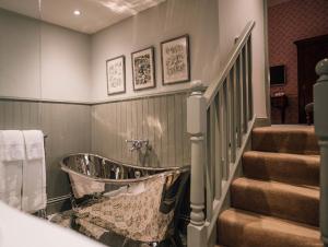 瑟索Forss House的楼梯旁带浴缸的浴室