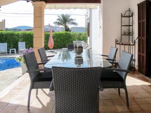 Cala MendiaHoliday Home Dolce Farniente - PCN130 by Interhome的一个带游泳池的庭院内的一张餐桌和椅子