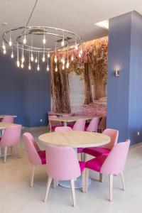 贝尼多姆Hotel BCL Levante Club & Spa 4 Sup - Only Adults Recomended的一间带桌子和粉红色椅子的用餐室