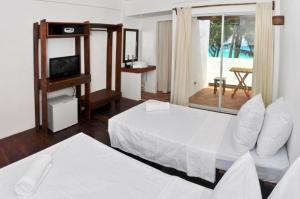 长滩岛长滩岛可可旅馆的一间带两张床、一台电视和一个阳台的卧室