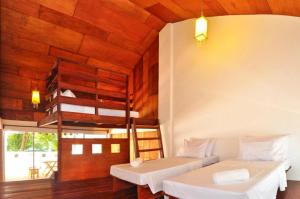 长滩岛长滩岛可可旅馆的一间带两张床铺的卧室,位于带木墙的房间内