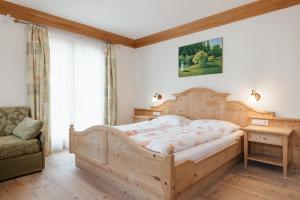 巴迪亚加尼西亚萨城市酒店的一间卧室配有一张木床和一把椅子