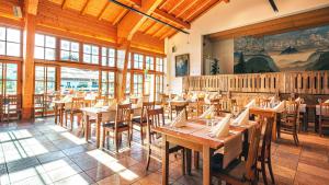 因泽尔Das Bergmayr - Chiemgauer Alpenhotel的一间设有木桌和椅子的餐厅