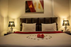 科威特Magic Suite Plus For Hotel Apartment的一间卧室,床上有两朵玫瑰