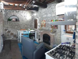 阿西西CASETTA delle ROSE的客厅设有石制壁炉和炉灶。