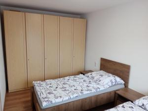 StrážovApartmán pod kostelem的一间卧室配有一张床和一个木制橱柜