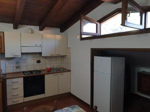 菲乌马尔博Appartamento Rosy的厨房配有白色橱柜和白色冰箱。
