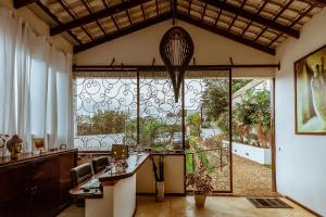 戈亚斯州上帕莱索Pousada Casa de Shiva的客房设有大窗户和桌椅