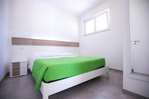 托雷桑塔萨宾娜Donnosanto Residence Pantanagianni的一间卧室配有一张带绿毯的床