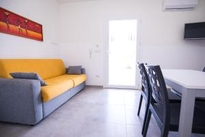 托雷桑塔萨宾娜Donnosanto Residence Pantanagianni的客厅配有黄色的沙发和桌子
