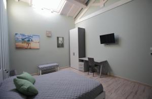 图斯卡尼亚La CASA DEGLI ARTISTI的一间卧室配有一张床、一张书桌和一台电视