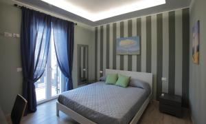 图斯卡尼亚La CASA DEGLI ARTISTI的一间卧室配有一张带绿色枕头的床和一扇窗户