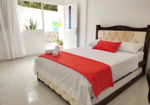 埃尔扎伊诺Hotel Manakin Tayrona的一间卧室配有一张带红色毯子的大床