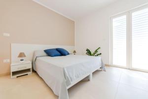 托雷圣乔万尼乌Case Vacanza Apollo的白色卧室配有蓝色枕头的床