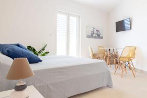 托雷圣乔万尼乌Case Vacanza Apollo的白色卧室配有带蓝色枕头和椅子的床