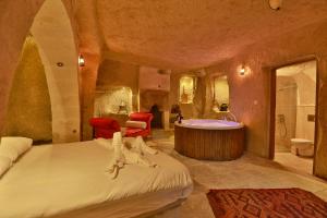 内夫谢希尔Cappadocia Eagle Cave Inn的一间卧室设有一张大床和一个浴缸