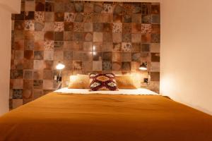 UsseiraObidos Rural Chic House的卧室配有一张带瓷砖墙壁的床