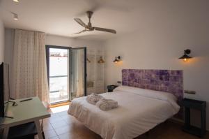 圣何塞Hotel La Posada De Paco - Spa & Adults Friendly的一间卧室配有一张带吊扇的床