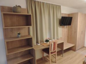 芬德尔斯Pension Burgschroffen的小房间设有书桌和电视