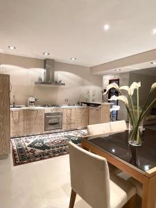 奥尔比亚Double A Luxury Apartment的一间带桌椅的厨房和一间用餐室