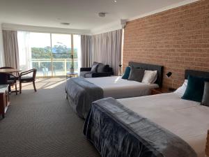 尼尔森湾滨海度假村的酒店客房带两张床和砖墙