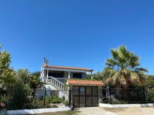 伊里斯斯Ikidiki Beach Villa的一座带大门和棕榈树的房子