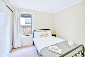 布里德波特Port View Escape的白色的卧室设有床和窗户