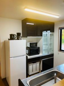 Matsuda松田テラスB Matsuda Terrace B的厨房配有白色冰箱和微波炉
